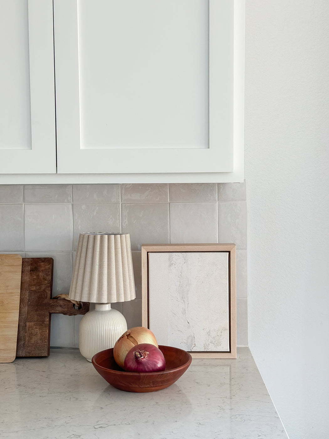 a bowl of apples sits on a kitchen counter